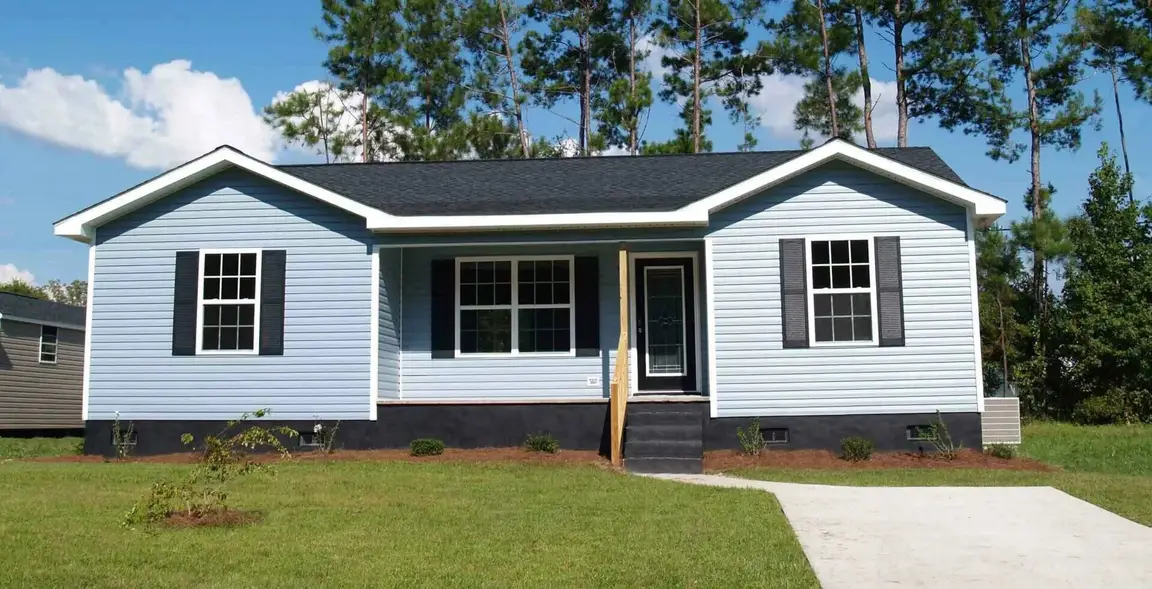 Newly built or remodeled modest single family home with green lawn and driveway