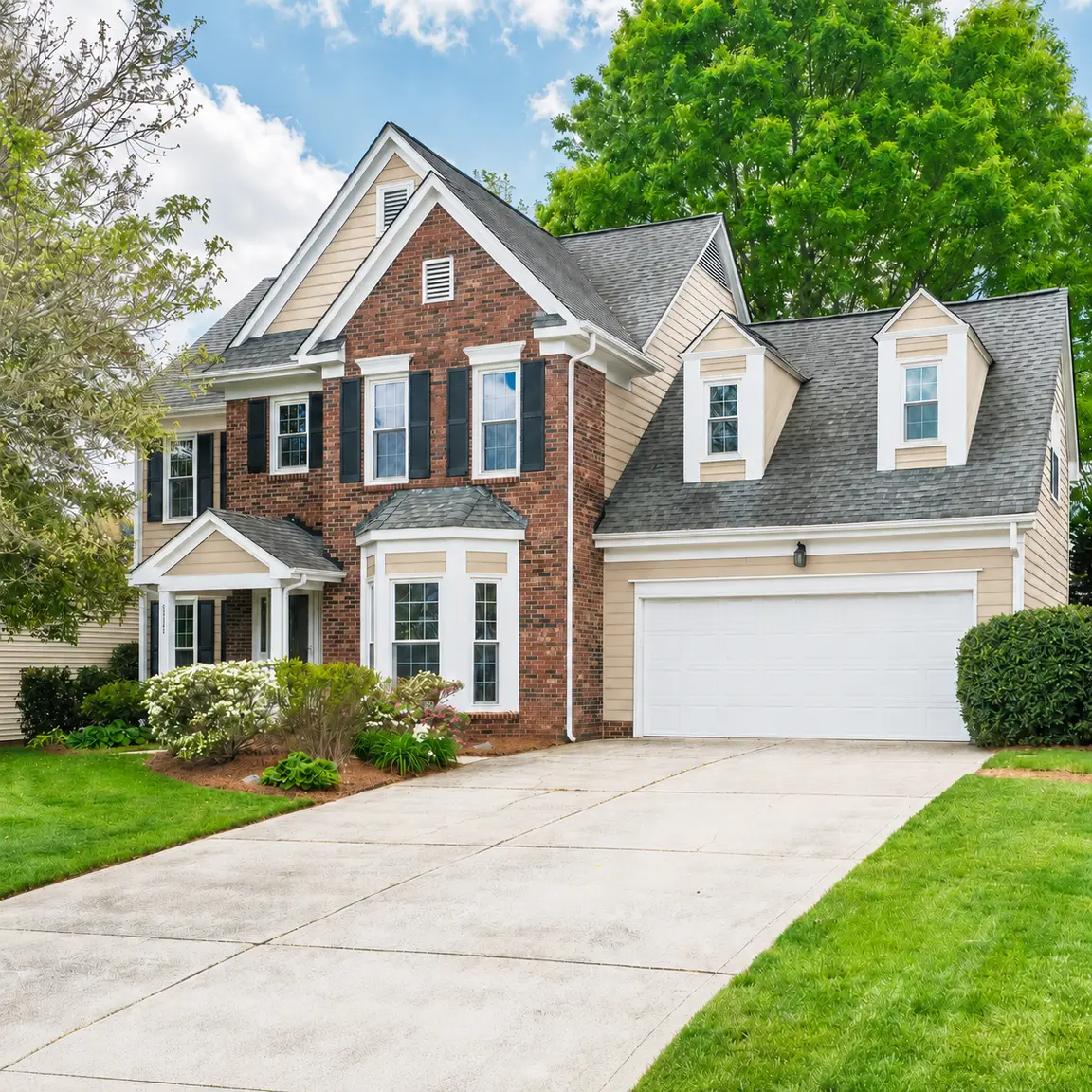 Two-story brick and beige home with an attached garage in Ballantyne, North Carolina