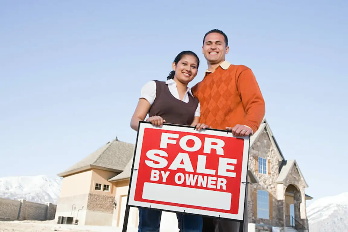 couple with for sale by owner sign selling house on their own