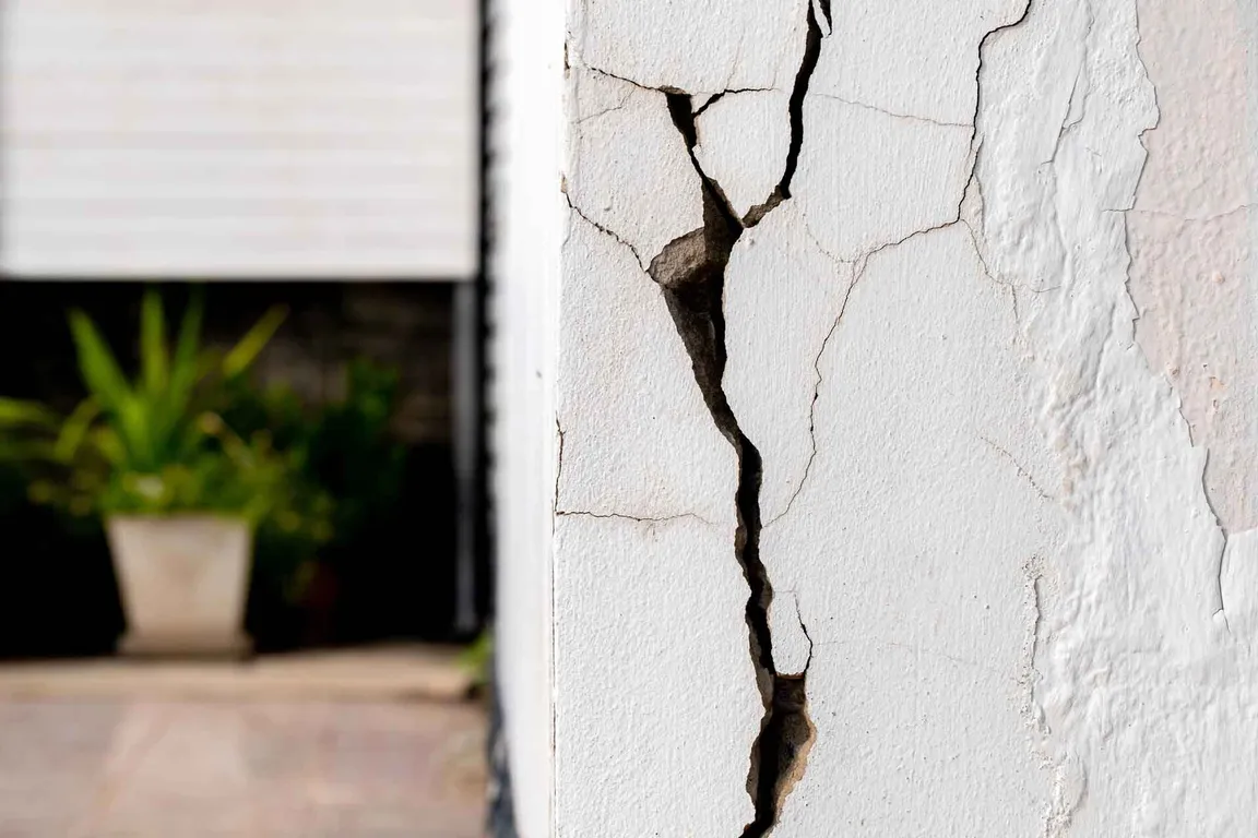 exterior of a window of a home with a cracked wall and structural damage
