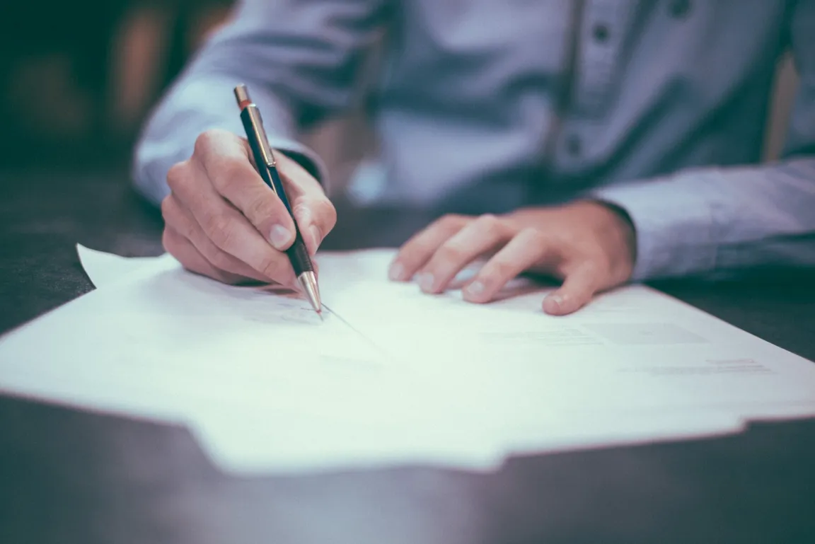 7 Documents You Need When Selling Your House in [market_city] or Cincinnati - Person signing papers