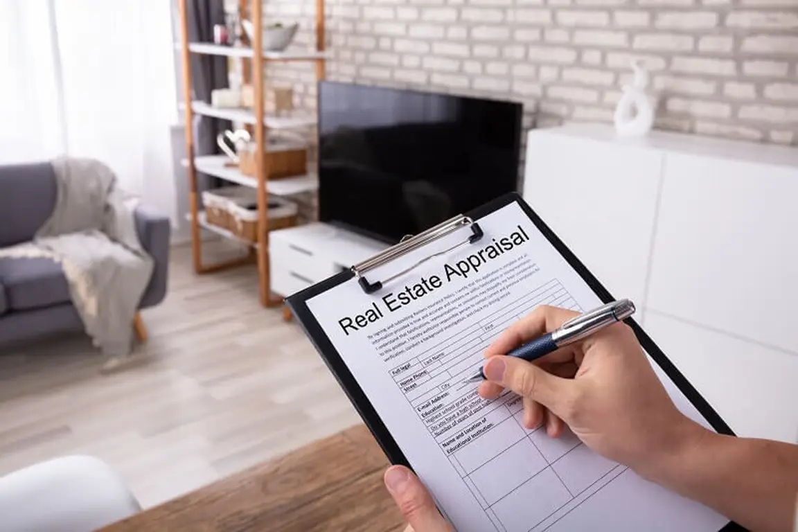 An appraiser crossing off items on a house appraisal