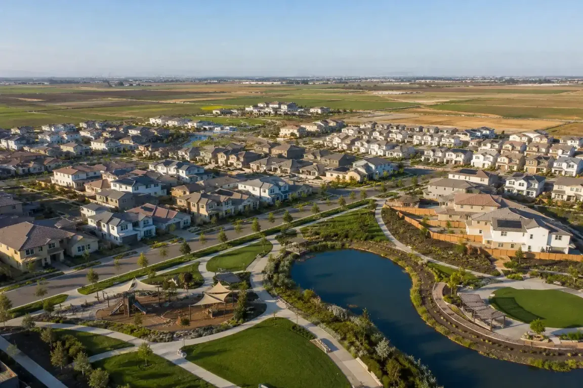 Aerial view of the Morada neighborhood in Stockton California featuring residential homes, landscaped parks, walking trails, and a pond during golden hour for sell my house fast Morada
