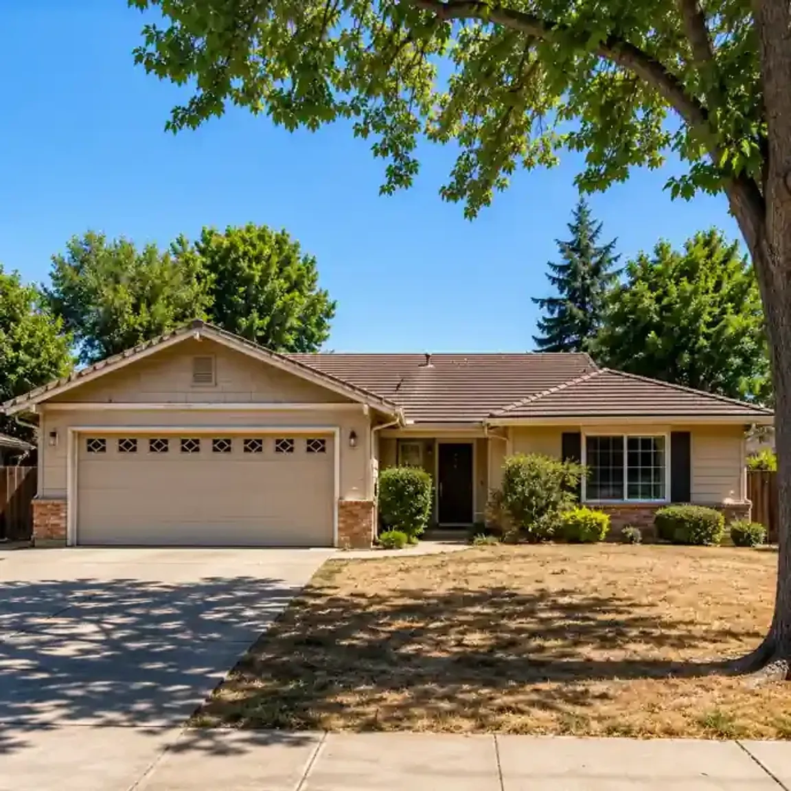 Sell my house fast in Clovis CA ranch style home with dry front yard and mature trees on a quiet residential street.