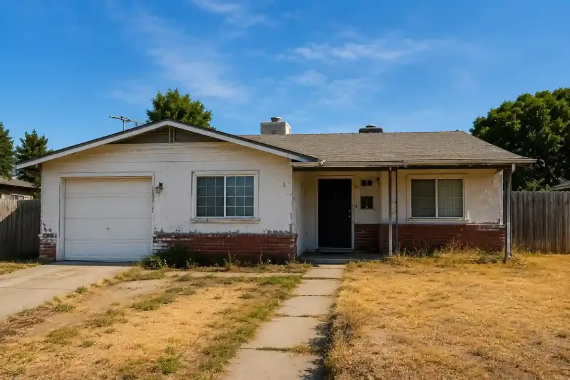Sell my house fast in Manteca, CA. Older fixer upper home with a dated exterior and dry lawn, representing a fast cash home sale without repairs or cleaning.