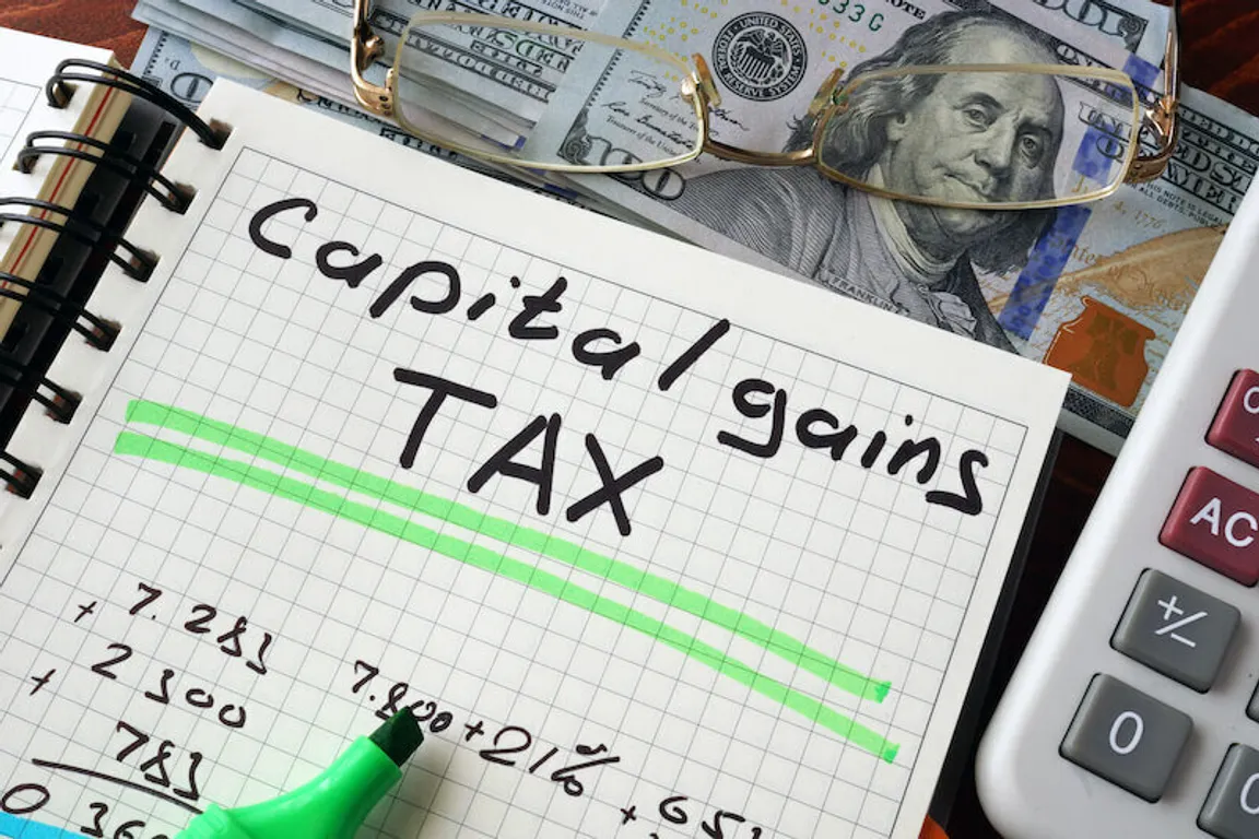 Notebook with capital gains tax sign on a table