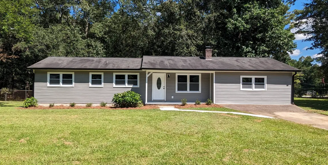 A ranch-style house with gray siding and white trim.