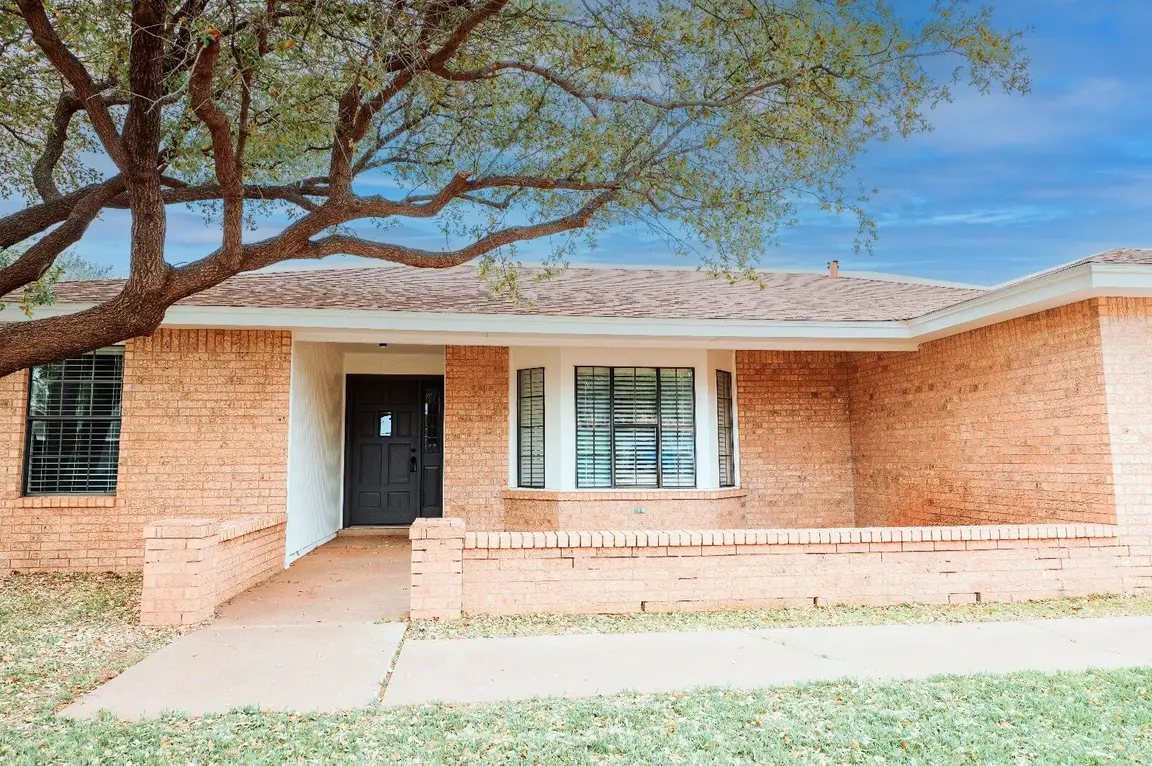 Brick Home With Tree And Black Front Door In Lubbock Texas, Example Of Properties Cash Buyers Purchase To Help You Sell Your House Fast