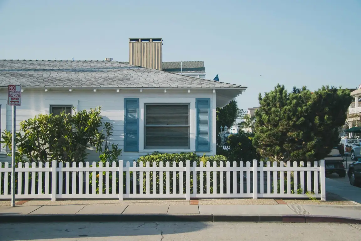 blue corner house with white picket fence