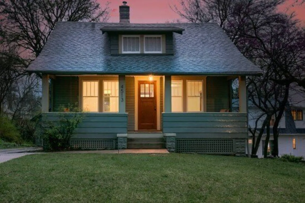 Newly remodeled house with new front porch and paint, by Anna Buys Houses.