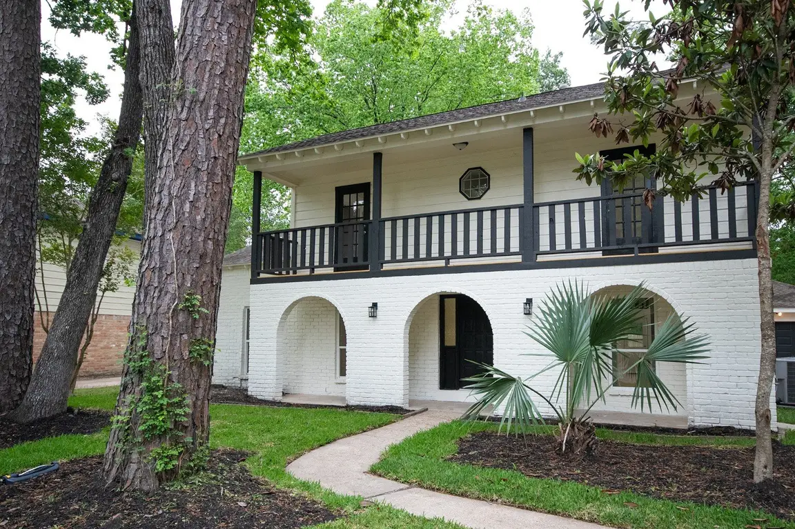 Renovated two-story house with a white exterior and covered porch
