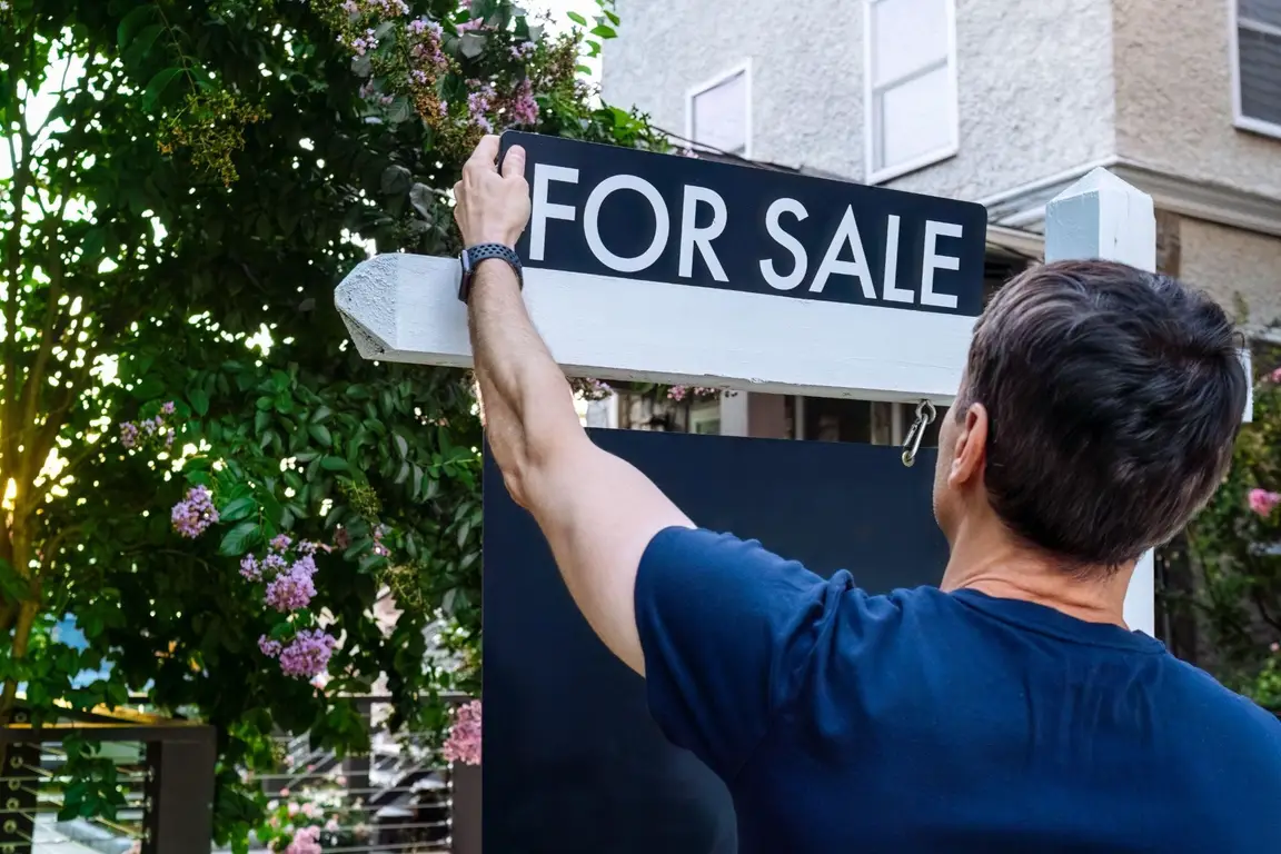 A Man Putting Up a Sale Signage | Home Selling
