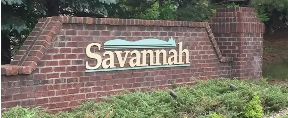 Savannah GA entrance sign on a brick wall.