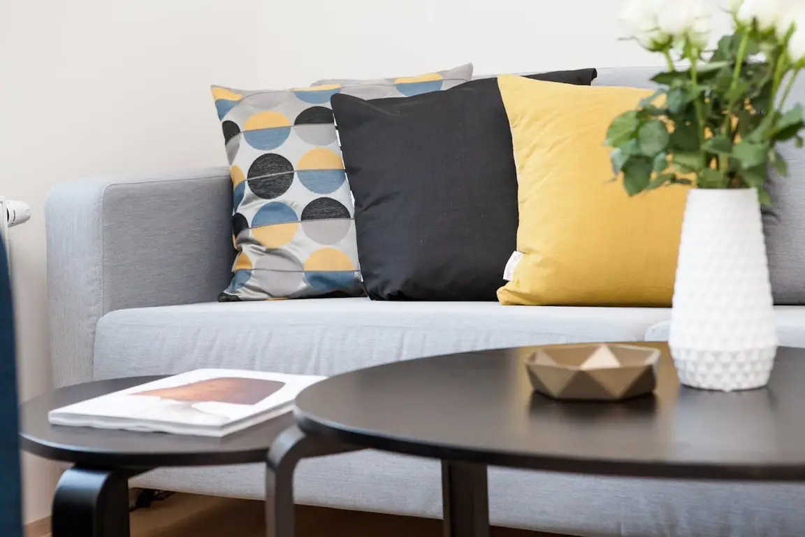 Sofa with three pillows next to a coffee table