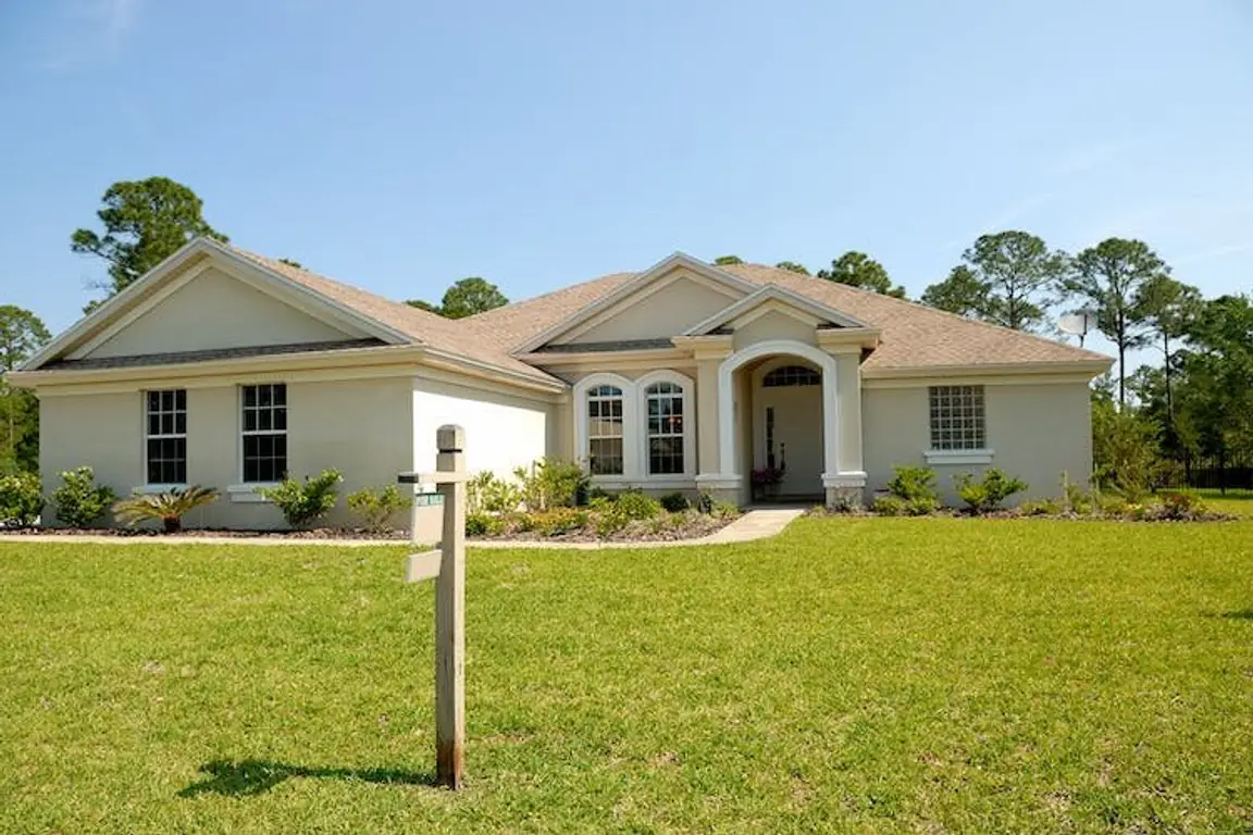 Big house with a for sale sign in the front yard