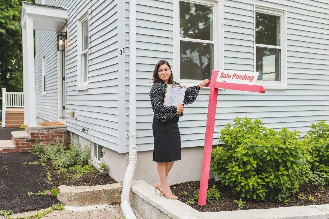a woman in front of the house attends to hosting a successful estate sale.