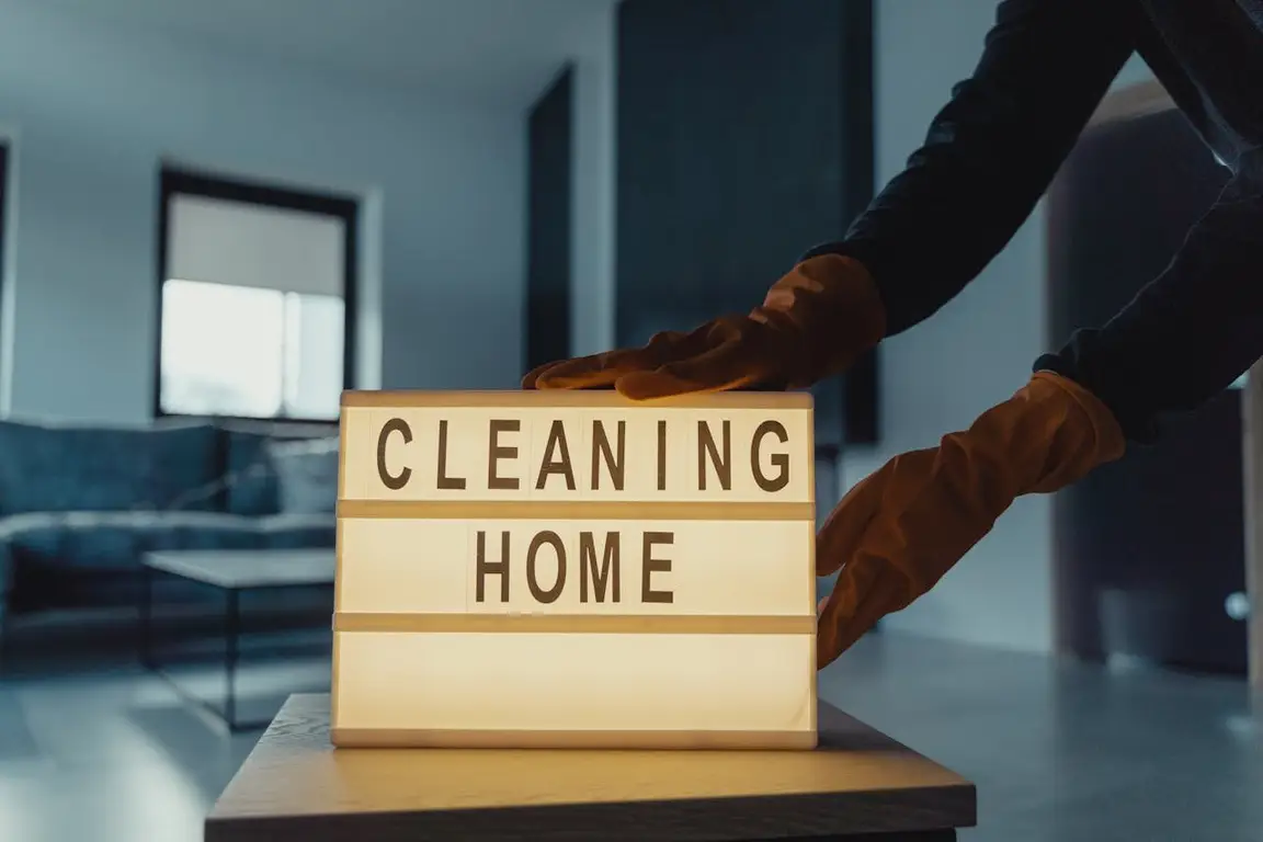 A person touching a lightbox that says “cleaning home”.
