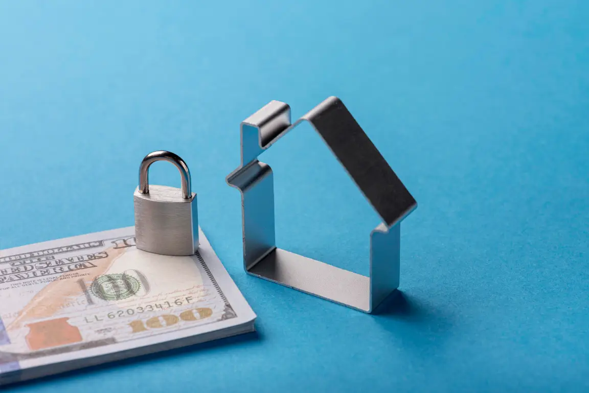 A lock on top of a bill beside a house.