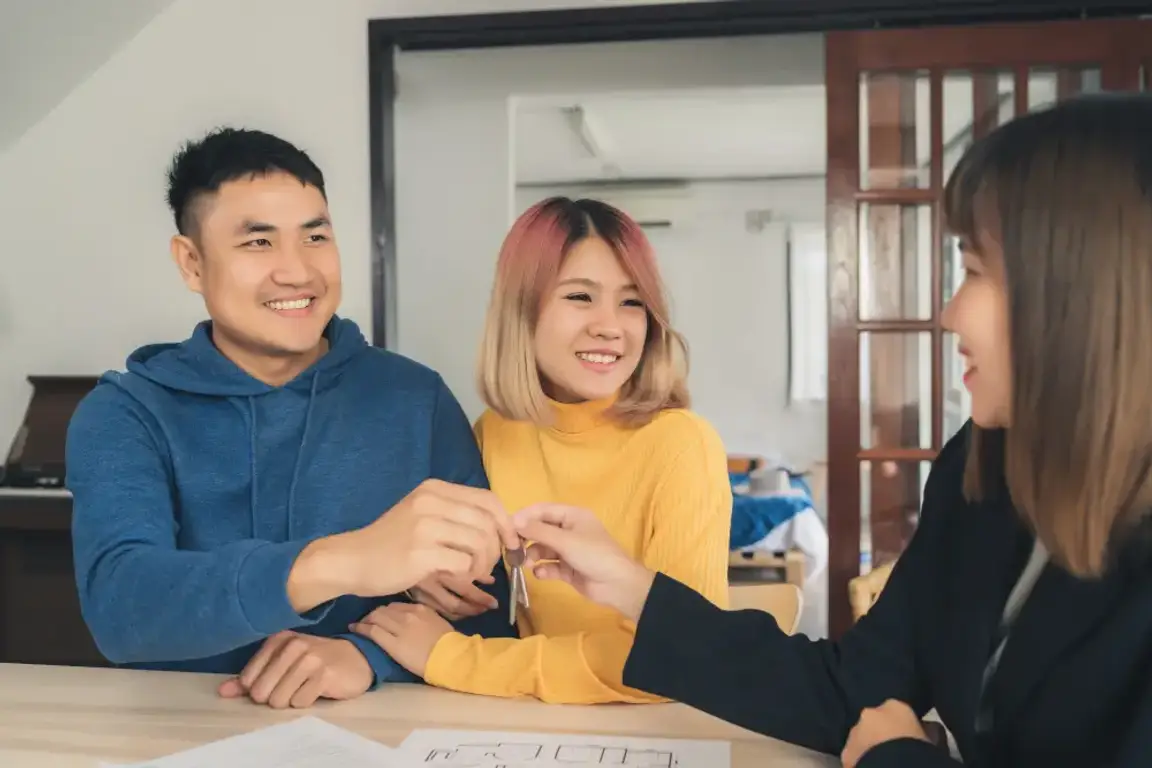 Asian couple shaking hands with an agent