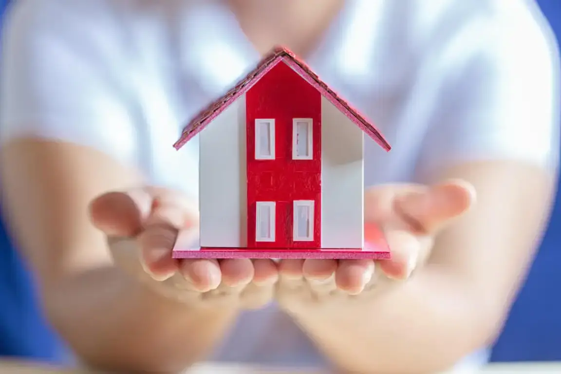 Man holding a red house