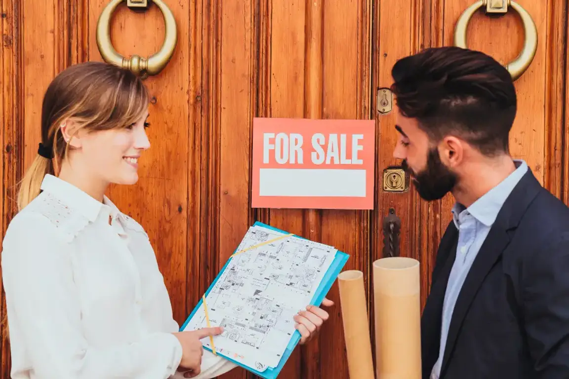 A woman selling a man a house