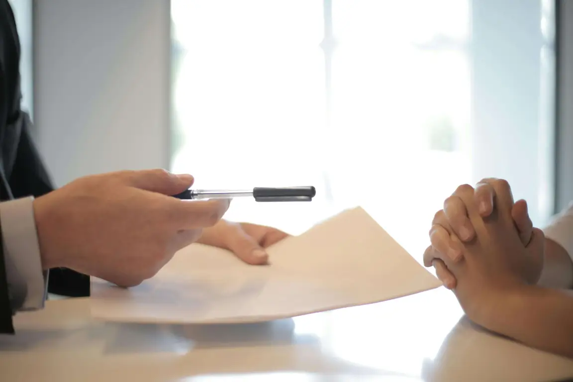 Two people sitting at a table with papers and pen. A cover in How to Spot a Good Real-Estate Investment and Buy a House Quickly in Wilmington blog post.