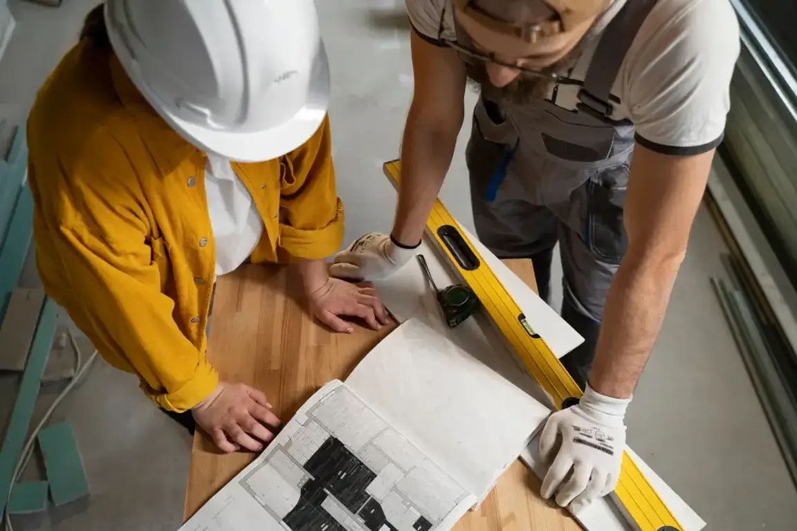 two construction workers looking at a blueprint