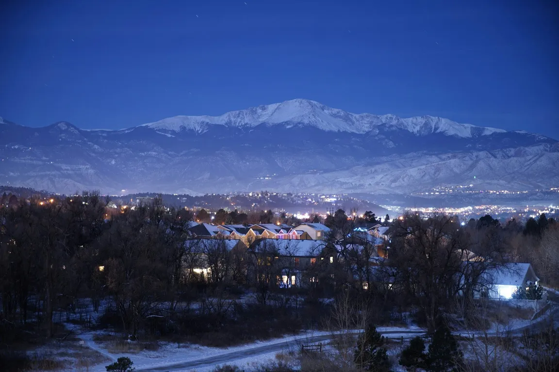 Houses below a snow-covered mountain on a clear day