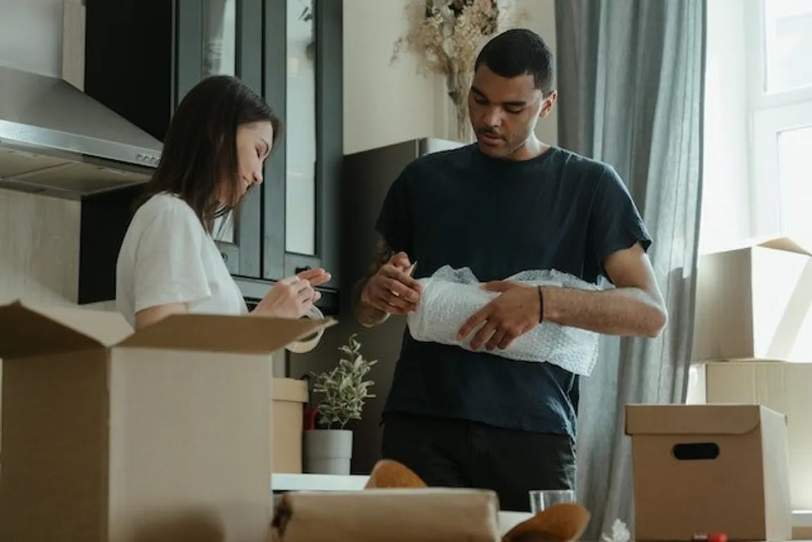 Young couple packing their belongings because they've sold their house.