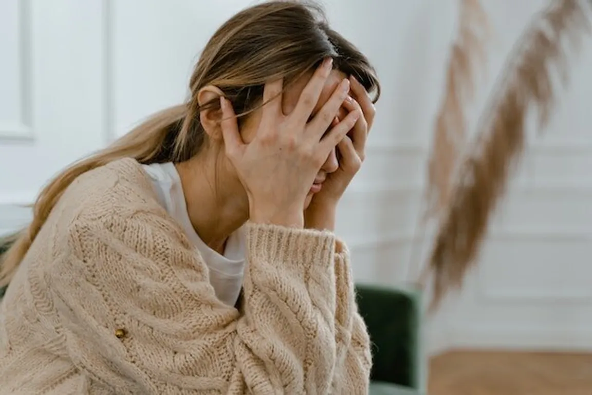 woman in tan sweater worrying about a foreclosure.