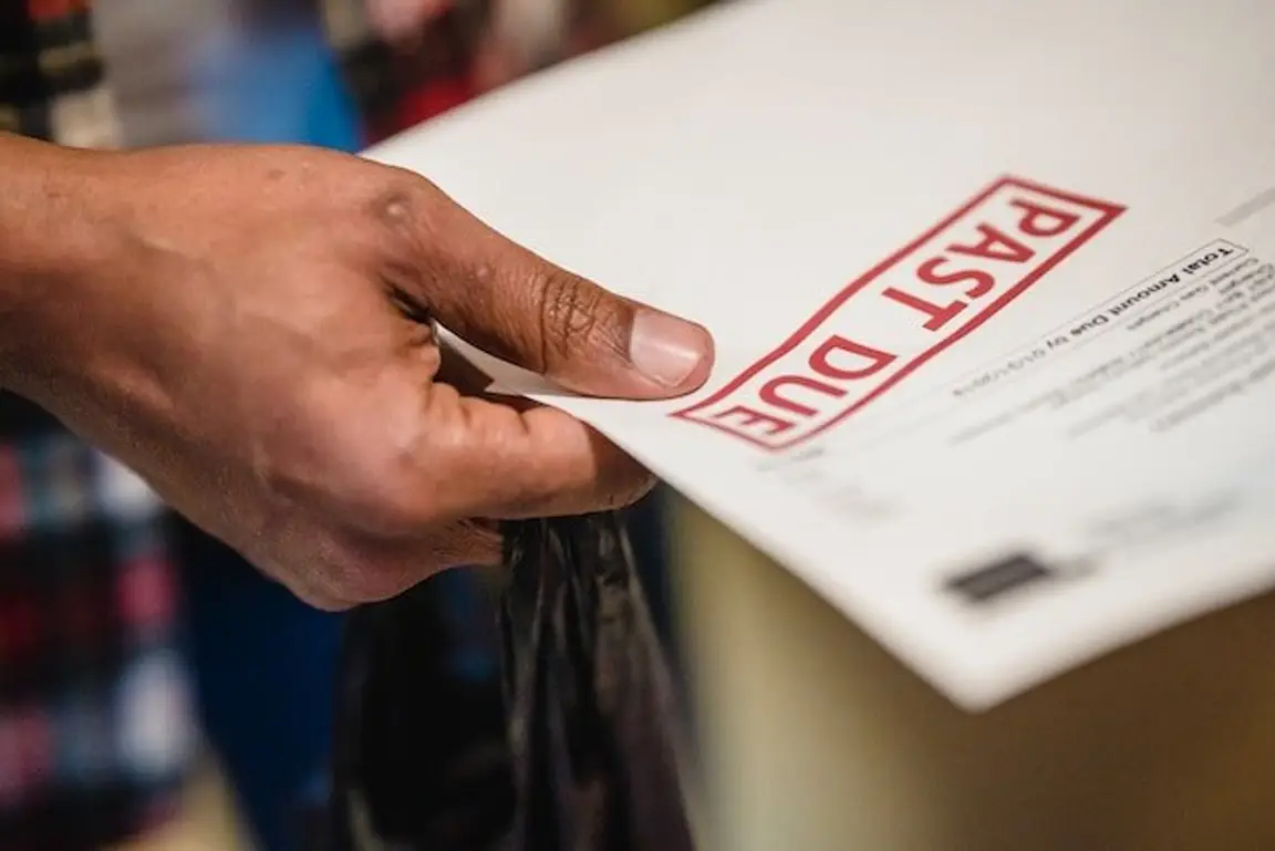 man holding past due bills