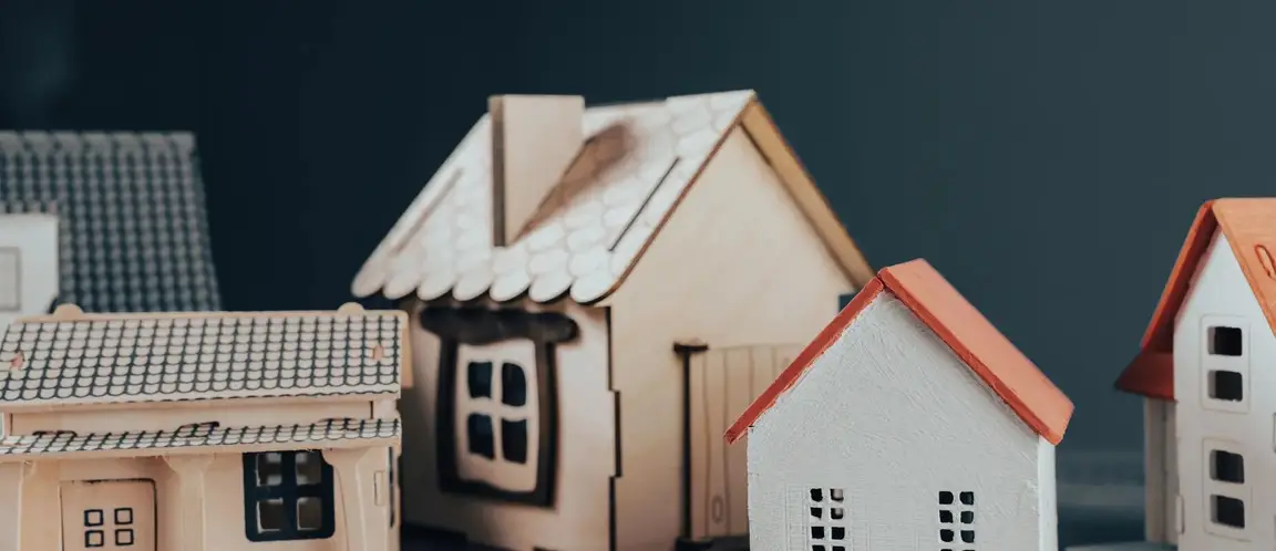 small model houses grouped together representing residential properties and real estate ownership
