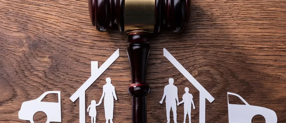 judge’s gavel above split house and family figures representing property division during divorce