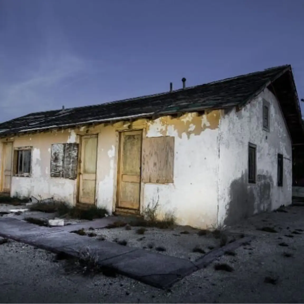 boarded-up condemned house in poor condition with peeling paint and visible damage in Oregon