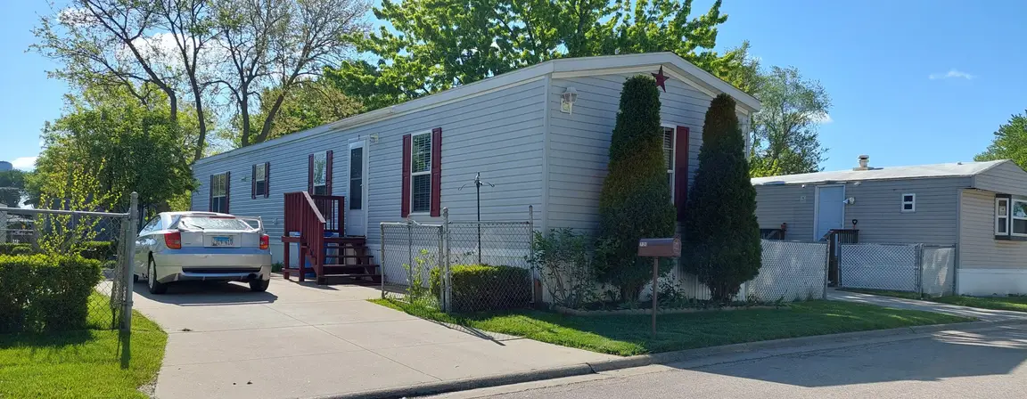 Mobile home with driveway in Illinois residential community.
