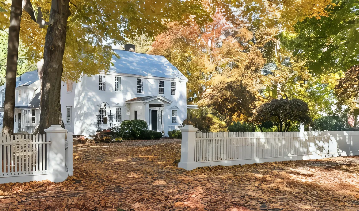 Charming white house surrounded by autumn foliage in Bridgewater, MA.