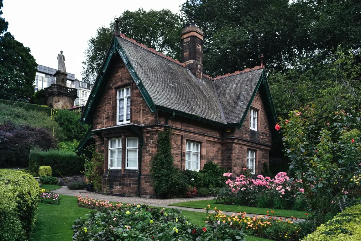 a brick house sitting in a nice garden