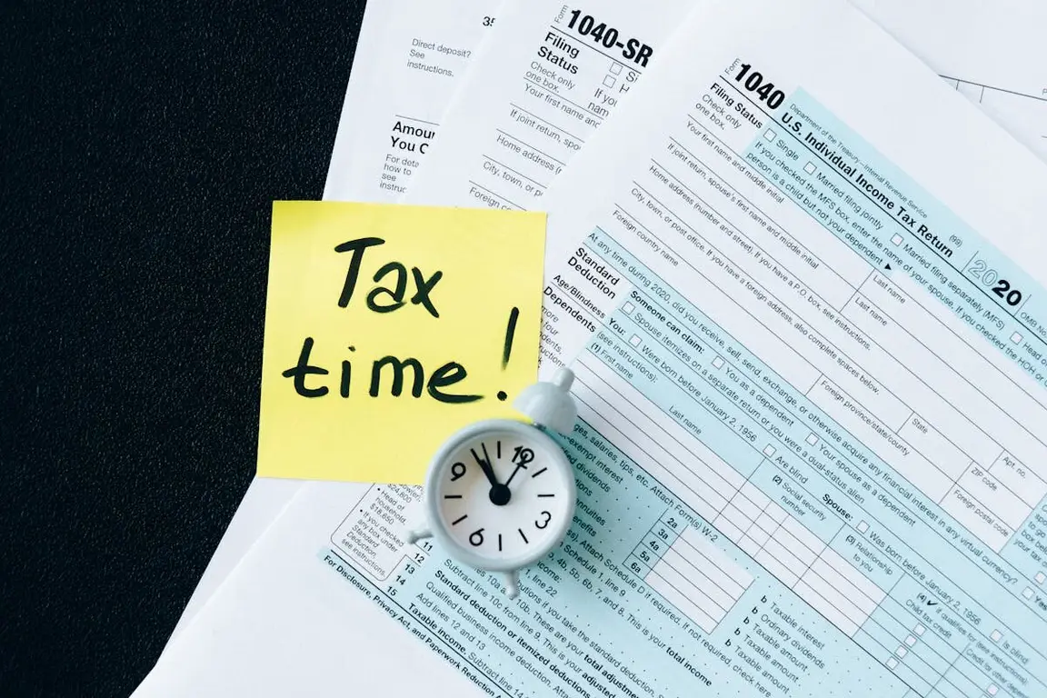 A bunch of tax papers with a small clock