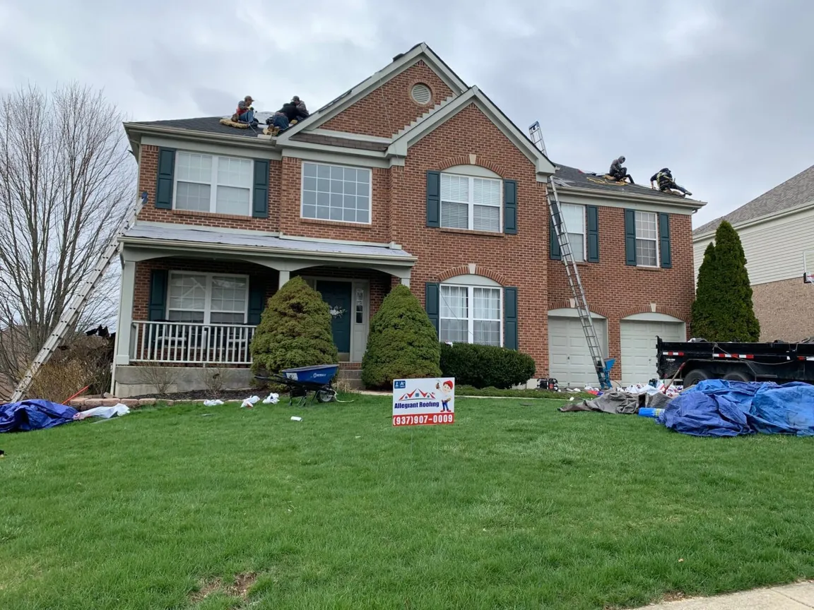 A group of men are conducting a roof inspection on a house.