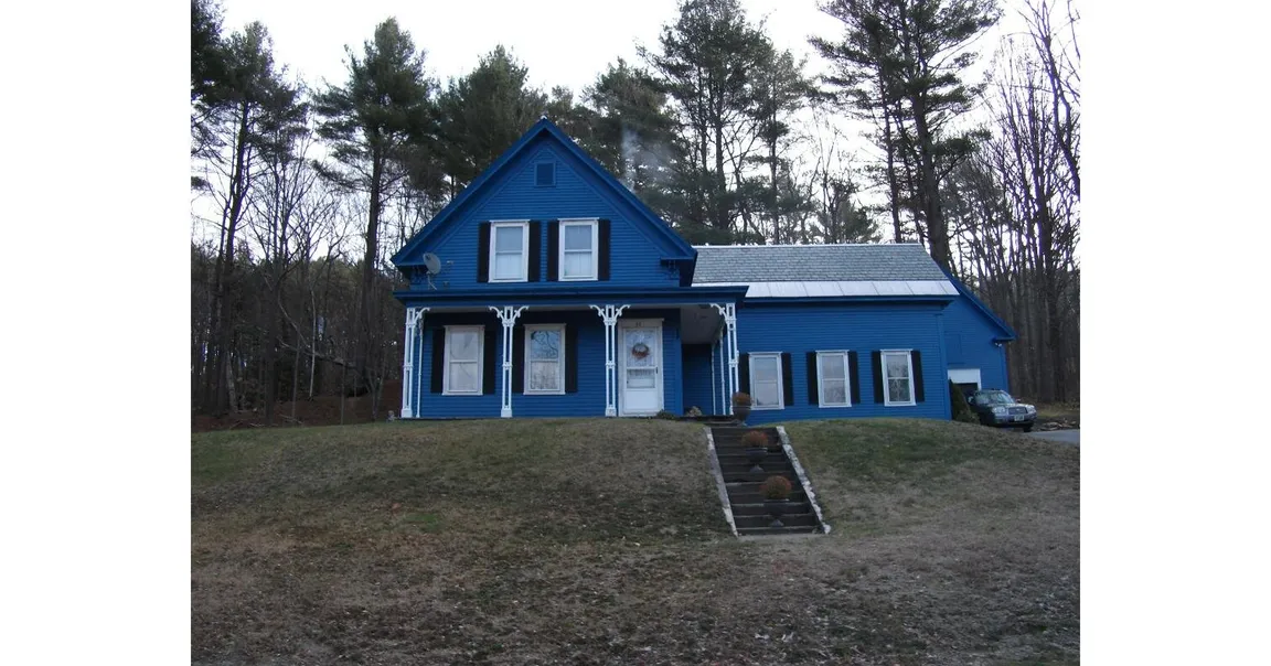 Blue farmhouse-style home in Spofford, New Hampshire, representing a property with delinquent property taxes