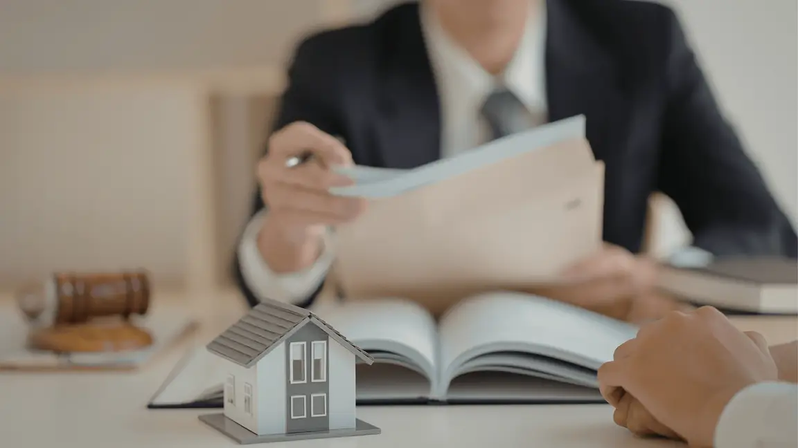 Airbnb Licensing in Orlando | Hands reviewing property paperwork beside a small house model