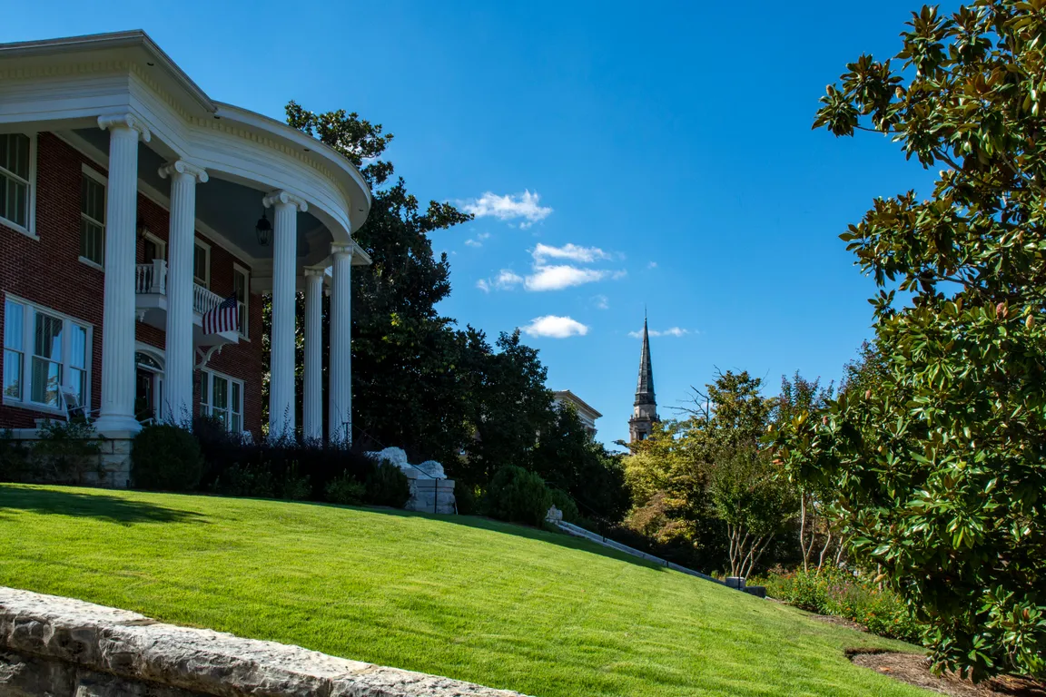 Stately brick house with columns on the front, perched on a hill overlooking downtown Rome, Georgia.
