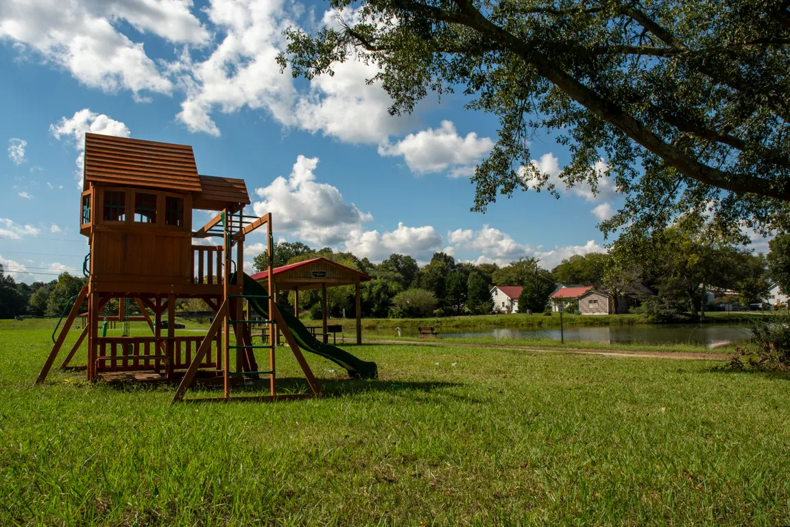 Scenic view of a lake in Floyd County, GA, with a family’s playset in the foreground and homes along the waterfront.