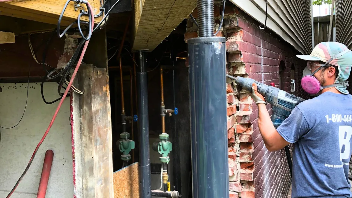 Contractor demolishing brick foundation.