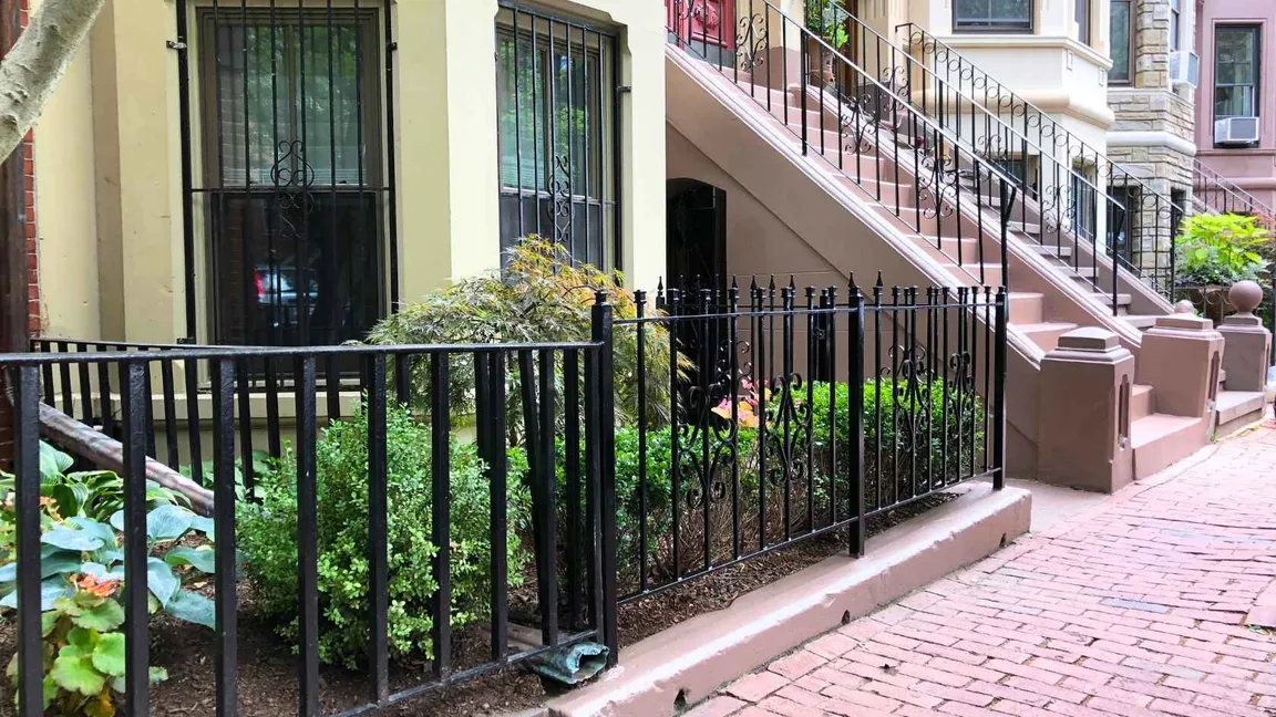 Row of houses in downtown Boston, MA with a well-maintained brick walkway in front.