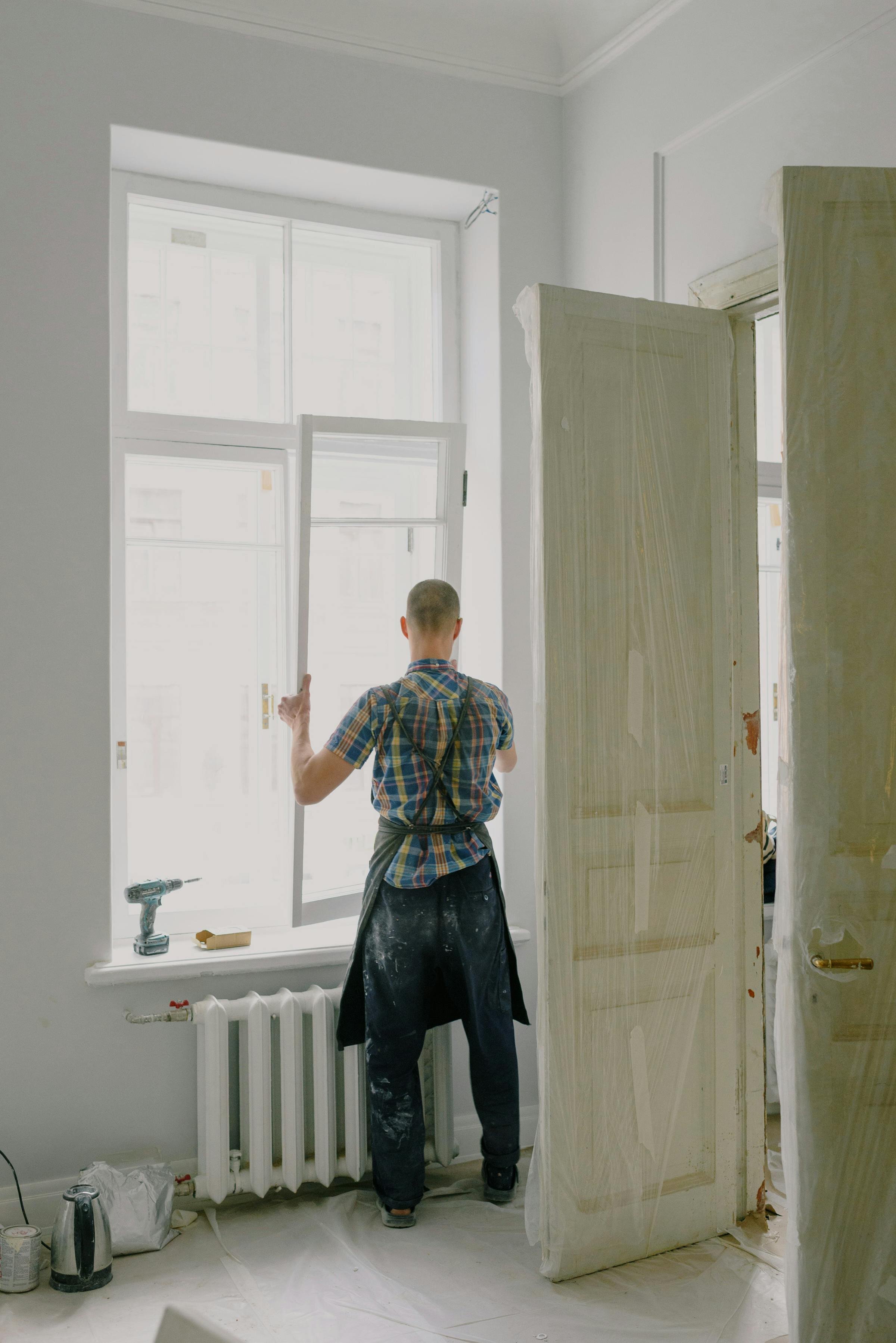 Mr. Junk Removal worker installing a window