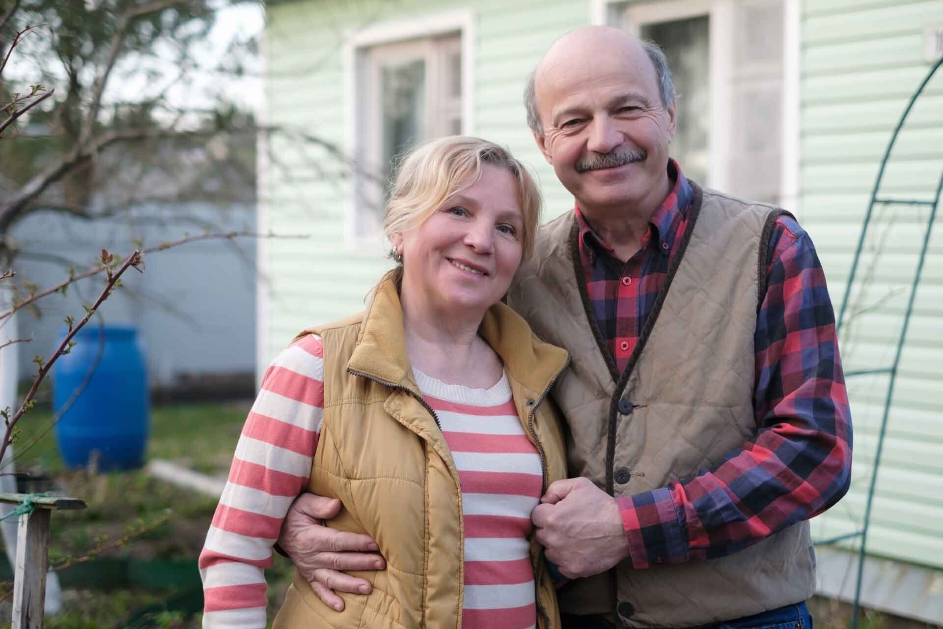 smiling middle aged couple in backyard of home