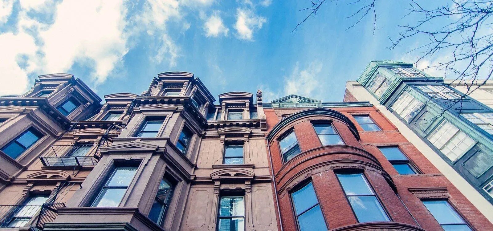 Front of luxury townhomes and office buildings looking up towards a blue sky