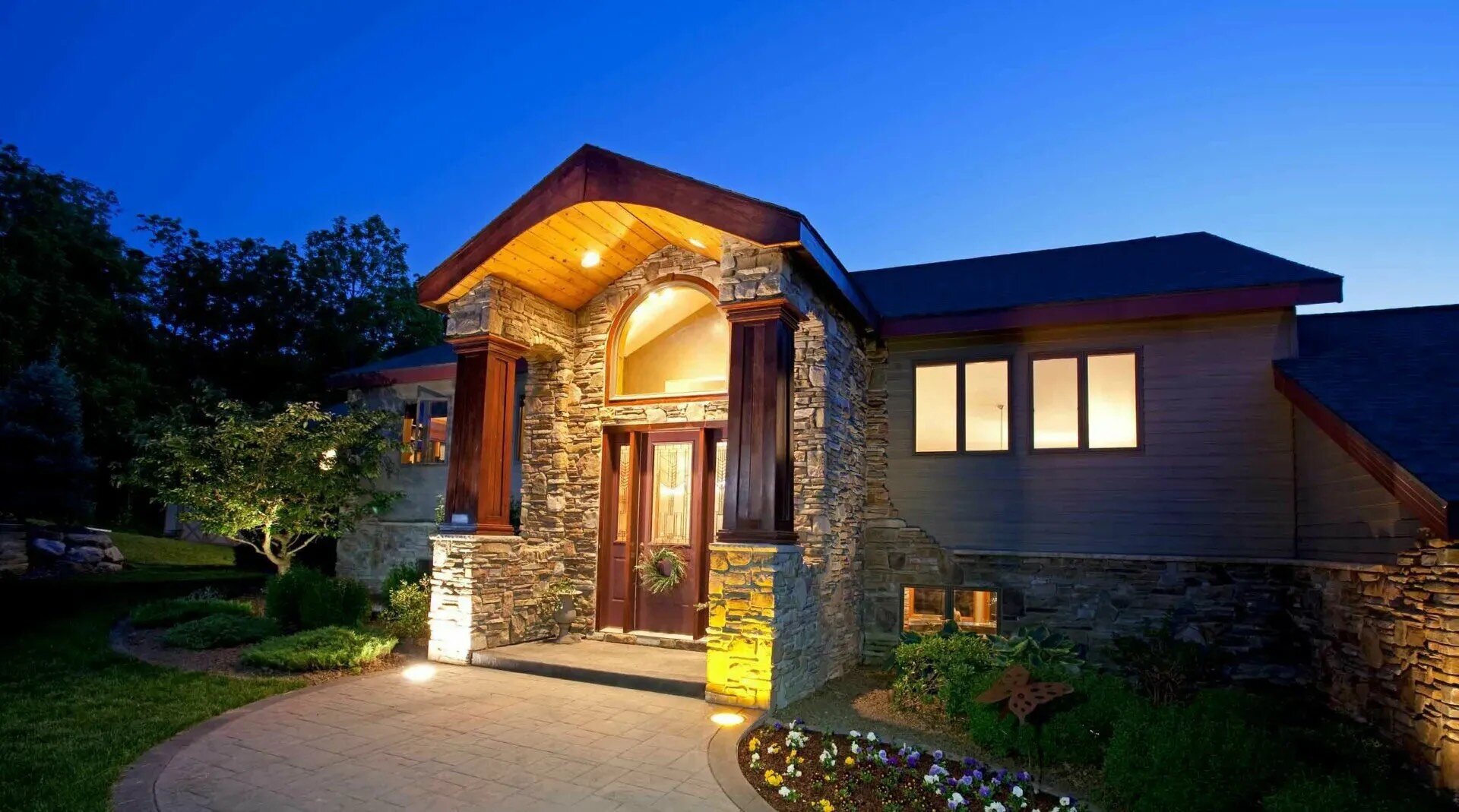 Elegant stone and wood facade front of luxury home in the evening