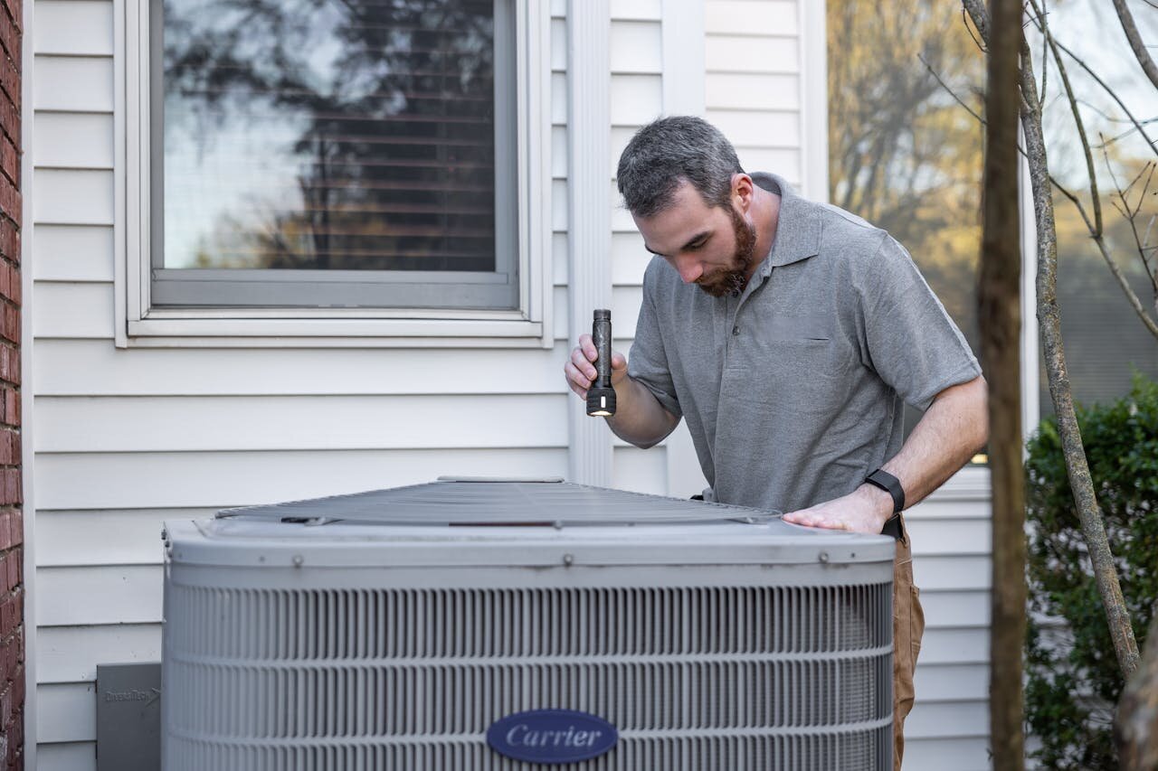 [company] tech inspecting an HVAC unit